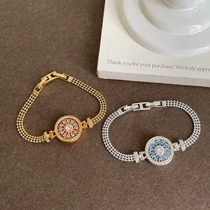 Détail de bracelets boussole rotatifs en zircon avec chaînes en maille de montre élégants.