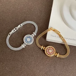 Vue détaillée de bracelets boussole rotatifs sertis de zircons colorés et chaîne à maillons.