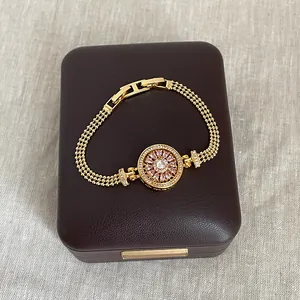 Gros plan d'un bracelet boussole rotatif en zircone doré sur une boîte à bijoux