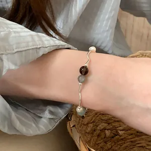 Vista macro detallada de pulsera para mujer con piedras naturales y perlas blancas