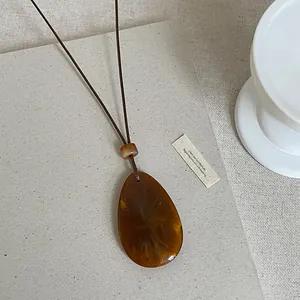 Detaillierte Nahaufnahme einer minimalistischen braunen Harz-Halskette für Damen
