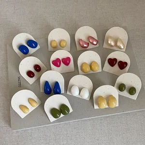Macro view of colorful drip oil heart and bean geometric stud earrings collection
