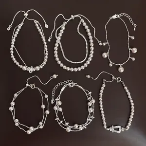 Detailed view of six different elegant silver-tone pearl bracelets for women