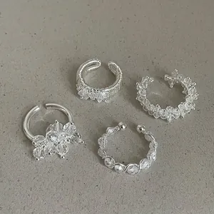 Macro view of minimalist silver rings with clear crystal beads and wire-wrap detail