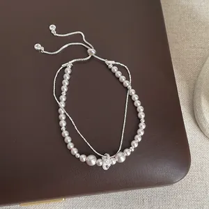 Detailed view of elegant multi-layered pearl bracelet with silver accents