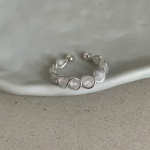 Macro detail view of an irregular silver wire wrap ring featuring faceted clear beads.