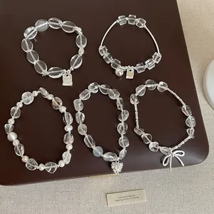 Vue détaillée de bracelets en cristal transparent avec breloques en argent