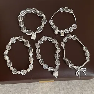 Variété de bracelets en cristal blanc avec des accents de nœuds en argent et de perles
