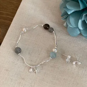 Pulsera de piedra natural con colgantes de estrella de mar y caracol con pendientes a juego.