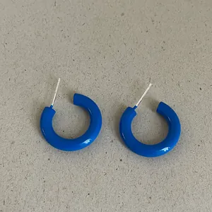 Bright blue glossy enamel C-shaped hoop earrings with silver-tone metal studs for her