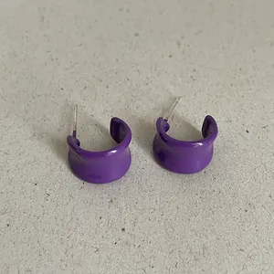 Macro view of purple drip oil geometric bean stud earrings with a smooth glossy finish.