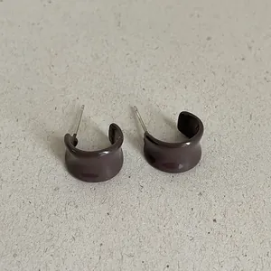 Close-up view of coffee brown enamel drip oil C-shaped geometric stud earrings for women