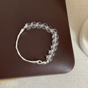 Détail d'un bracelet minimaliste en quartz clair avec élément en métal argenté