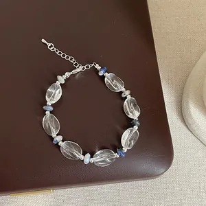 Détail d'un bracelet en perles de quartz clair irrégulier avec accents de pierres bleues