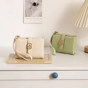 Primer plano de carteras con patrón agrietado en crema y verde matcha sobre mesa.