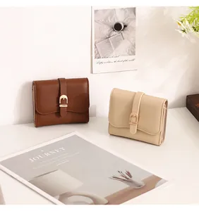 Detailed view of two elegant leather short wallets with decorative golden belt buckles