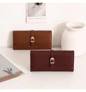 Elegant long leather wallets for women in brown and burgundy with gold buckles.