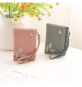 Women's elegant pink and grey floral print short wallets displayed with daisies