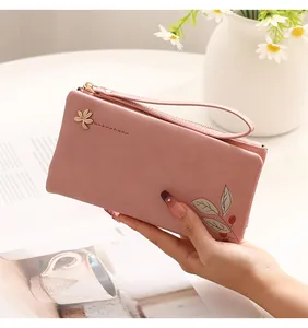 Elegant pink long PU leather wallet for women with floral print and wrist strap detail.