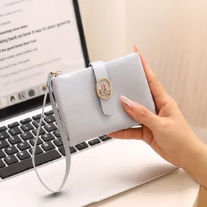 Vista detallada de una elegante cartera corta para mujer en azul grisáceo con textura
