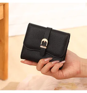 Handheld black pebbled leather short wallet for women featuring a metal belt buckle buckle.