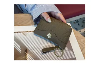 Vue détaillée du porte-monnaie en cuir gaufré marron avec ornement de fleur dorée