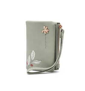 Detailed view of sage green women's short wallet with floral print and wristlet strap