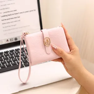 Cartera compacta rosa para mujer con textura de cuero agrietado y correa.