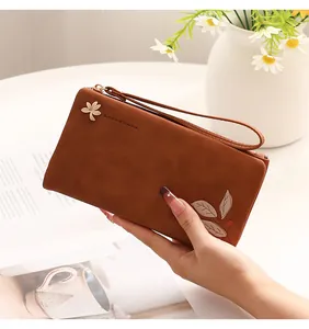 Detailed view of brown PU leather long wallet featuring leaf print and wrist strap