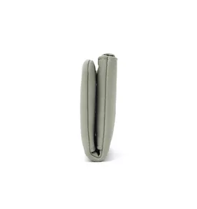 Side view profile of a compact sage green bifold wallet for women showing overall thickness