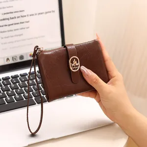 Vista detallada de cartera marrón para mujer con textura craquelada y cierre dorado