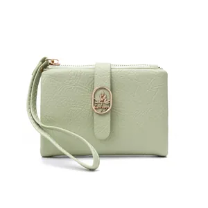 Detalle de billetera para mujer verde matcha con textura de grietas y logotipo dorado