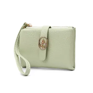 Cartera corta para mujer en verde matcha con textura agrietada y cierre decorativo de hoja.