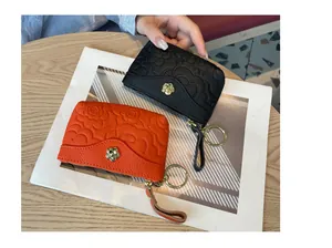 Vue détaillée d'un mini porte-monnaie en cuir gaufré avec motif floral et porte-clés