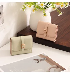 Short women's wallets with belt buckle detail in mint green and blush pink colors.