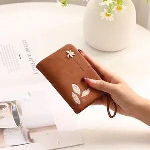Detailed view of a brown floral print short wallet featuring an elegant wrist strap