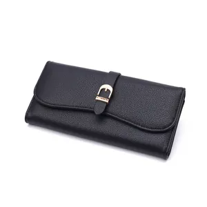 Close-up of black textured long wallet for women with gold decorative buckle detail.