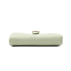 Vista detallada del lateral de cartera de cuero verde matcha con textura agrietada.