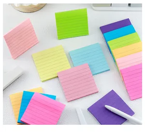 Close-up of vibrant lined sticky notes in various colors on a white textured desk surface
