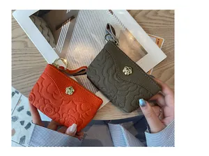 Vue détaillée de mini porte-monnaie en cuir avec motifs floraux gaufrés élégants