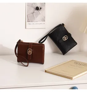Primer plano de carteras con textura agrietada en marrón y negro sobre un escritorio blanco.