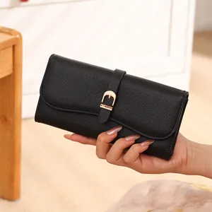Close-up of black pebbled leather long wallet with elegant gold buckle strap detail