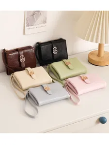 Carteras cortas para mujer en seis colores con textura crackle única y elegante hebilla metálica de hoja