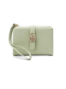Cartera corta para mujer en verde matcha con textura agrietada y cierre de hoja dorada