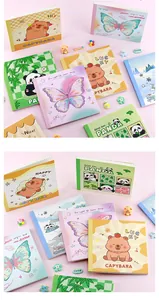 Detailed view of various cute cartoon animal and butterfly themed square grid notebooks