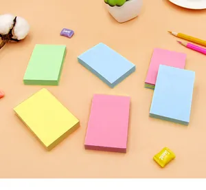Top-down view of colorful rectangle sticky note pads displayed on a warm orange background