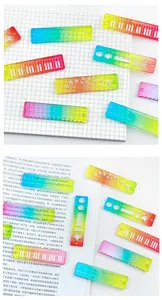 Set of candy-colored transparent rainbow rulers with creative patterns on grid paper