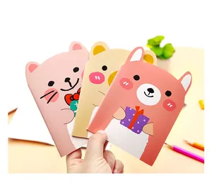 Close-up of three cute bear-themed pocket notebooks with colorful animal designs