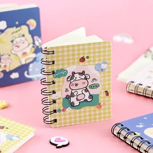 Small portable spiral notebook featuring cute cartoon cow on yellow checkered cover
