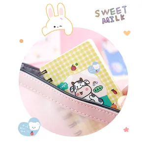 Close-up of a cute cartoon cow mini spiral notebook tucked in a pink pencil case.